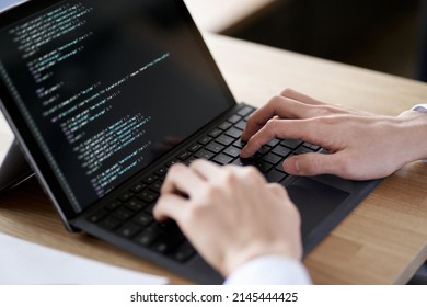 Asian Programmer Writing Code On A Laptop