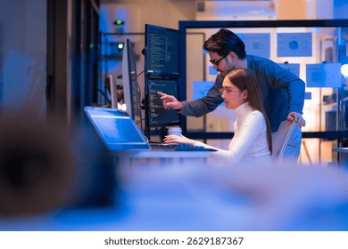 Asian programmers collaborating on software development at night, focused on writing code across multiple monitors in a tech office environment  Programmers Collaborating on Software Development 