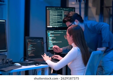 Asian programmers collaborating on software development at night, focused on writing code across multiple monitors in a tech office environment  Programmers Collaborating on Software Development 