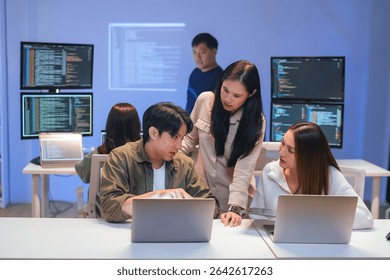 Asian programmers collaborating on software development at night, focused on writing code across multiple monitors in a tech office environment Programmers Collaborating on Software Development - Powered by Shutterstock - Get 15% off with code: PIKWIZARD15