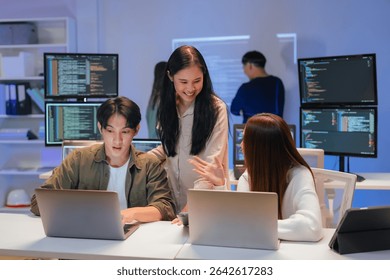 Asian programmers collaborating on software development at night, focused on writing code across multiple monitors in a tech office environment Programmers Collaborating on Software Development - Powered by Shutterstock - Get 15% off with code: PIKWIZARD15