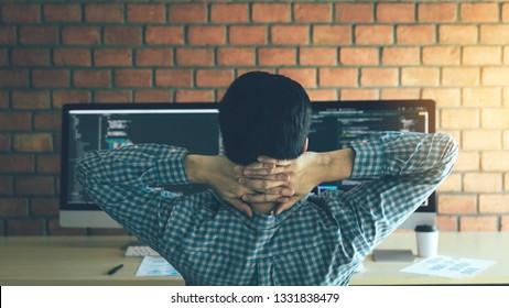 Asian Programmers Man Are Relaxing And Looking At The Code On The Computer Screen In The Office.