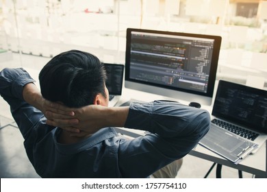 Asian Programmers Man Are Relaxing And Looking At The Code On The Computer Screen In The Office.