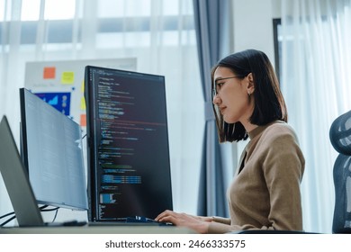Asian prompt engineer develop coding app with software data sitting in front of computer monitor at office