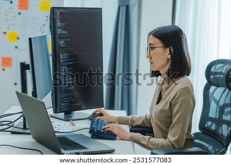 Asian prompt engineer develop coding app with software data sitting in front of computer monitor at office