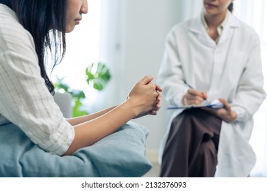 Asian psychology doctor examine and listen to woman patient at home. Attractive beautiful female physician give advise and consult to help young girl solve problem for Psychologic health care in house - Shutterstock ID 2132376093