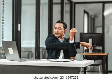 Asian real estate broker or legislation lawyer businessman straightening at office work desk. - Powered by Shutterstock