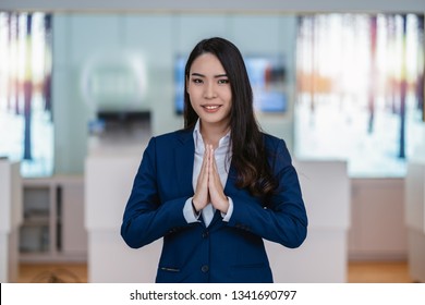 Asian Reception Welcoming The Customer Into Car Showroom Counter For Service The Customer Via Telephone,