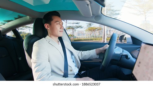 Asian Relaxed Man Is Driving Electric Car