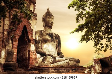 Asian religious architecture. Ancient sandstone sculpture of Buddha at Wat Mahathat ruins under sunset sky. Ayutthaya, Thailand travel landscape and destinations - Powered by Shutterstock