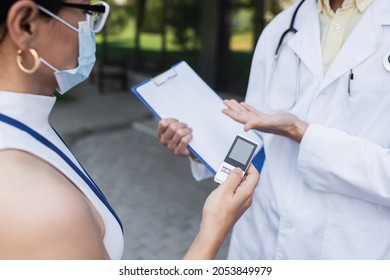 Asian Reporter In Medical Mask Holding Voice Recorder Near Doctor In White Coat