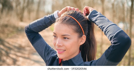 Asian Runner Getting Ready To Run Outside Tying Her Hair Into Ponytail For Hiit Workout Jogging Training. Happy Smiling Athlete Jogger Banner.