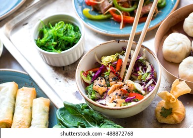 Asian Salad With Chicken Stir-fry, Bok Choy, Cabbage And Pepper, Dim Sum Bowl, Spring Rolls, Seaweed And Beef Salad With Vegetables. Chinese Style Dinner. From Above. Pan-asian Food. Selective Focus