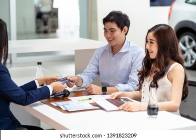 Asian Saleswoman Recieving The Credit Card From Couple Customer When Decision Buy The New Car After Sign Buy Contract In Showroom, Credit Card Mockup