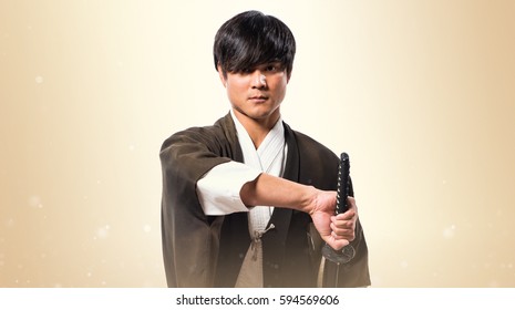 Asian Samurai Man With Katana On Ocher Background