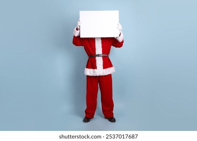 Asian Santa Claus in eyeglasses in Santa cap with gesture of Holding blank canvas isolated on blue background, Xmas. - Powered by Shutterstock