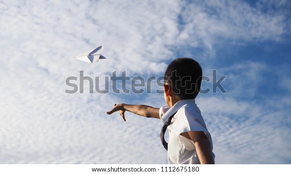 青い空の背景に紙飛行機を投げるアジアの少年 選択したフォーカス の写真素材 今すぐ編集