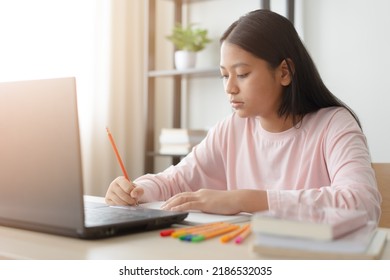 Asian school girl studying online class on laptop. Happy kid enjoy learning from home using laptop. - Shutterstock ID 2186532035