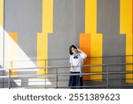 Asian school girl wearing glasses, holding up two fingers, posing cutely, studying hard and seeking knowledge to suit her lifestyle. Her determination to learn affects her daily routine and her future