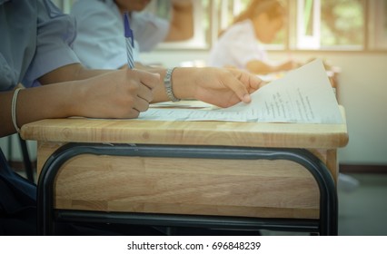 Asian School Students In Uniform Taking Examination And Writing Answer Sheet In Classroom, Educational School, View Of Having Exams In Class On Seat Rows, Education System Tests Concept Of Thailand