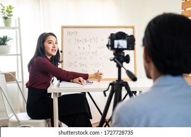 Asian school woman teacher working from home teaching online internet class to student studying from home. Man using camera to record girl digital live. Remote education class during covid19 pandemic.