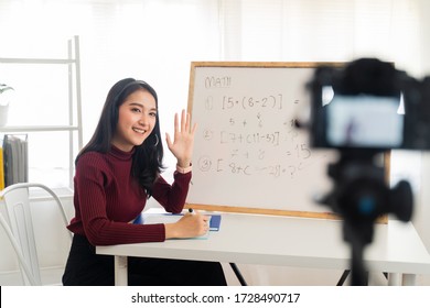 Asian school woman teacher working from home teaching online math subject to student studying from home. Girl using camera to record live on internet. Remote education class during covid19 pandemic.