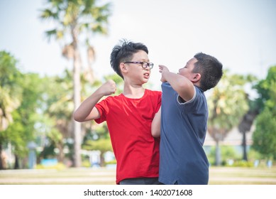 Asian schoolboy getting bullied ,Children fighting with classmate in school park. Bullying and violence in school concept.