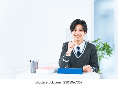 Asian schoolboy studying with tablet PC. - Powered by Shutterstock