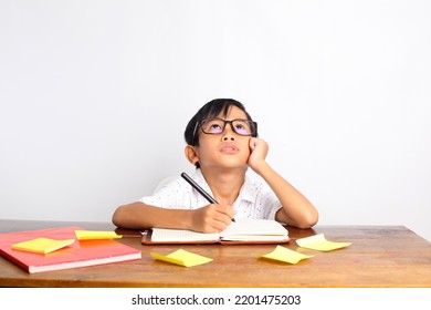 Asian schoolboy studying and thinking on the desk. Isolated on white background - Powered by Shutterstock