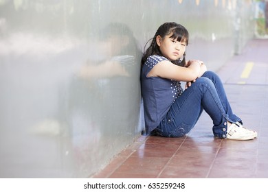 Asian Schoolgirl Alone In A School Corner. Bullying Concept.