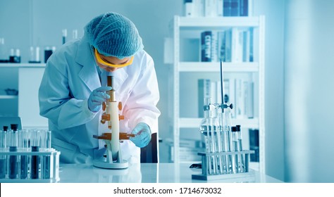 Asian Scientist Or Doctors Use Microscopes To Test For The Coronavirus (COVID 19). Or A New Flu Virus To Save Human Life In The Lab Or Hospital. Successful In Researching The Treatment Of Patients