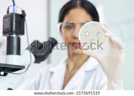 Asian scientist woman are and showing the results of drug resistant in the laboratory room.