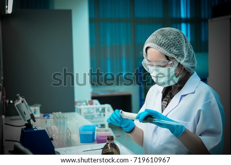 Asian Scientists holding big tube of experiment,Prepare experiment in lab,Thailand Scientist working in the laboratory