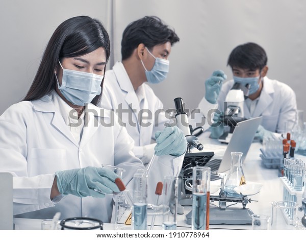 Asian scientists work in hospital pharmacology
science research lab. Woman medical scientist and researchers
teamwork analyzing innovative virus protective vaccines in health
care biology laboratory