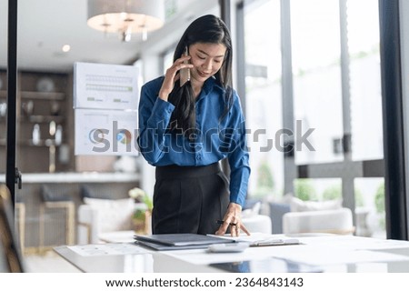 Beautiful confident asian secretary woman clever smart professional business woman  talking on phone  in office