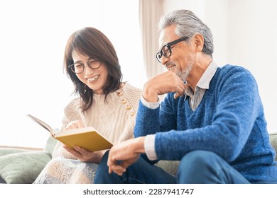 asian senior age couple reading a book
