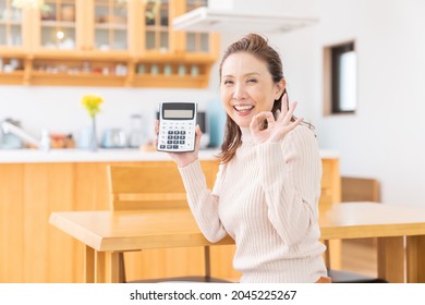 Asian Senior Age Woman Having An Electronic Calculator,smile