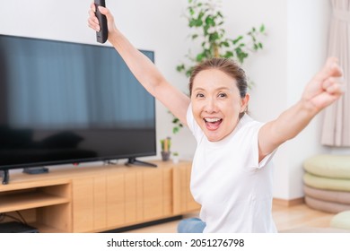 Asian Senior Age Woman Watching TV In Living Room