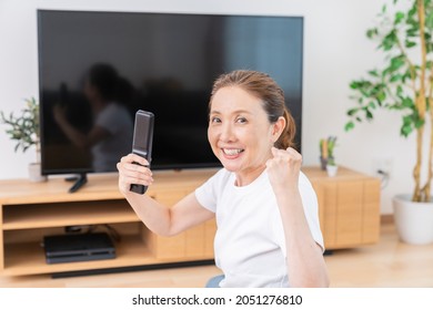 Asian Senior Age Woman Watching TV In Living Room