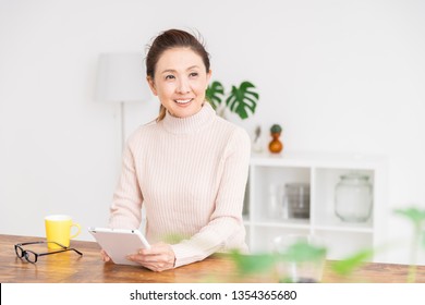 Asian senior age woman who uses tablet computer - Shutterstock ID 1354365680