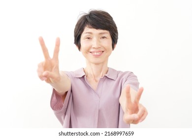 Asian Senior Aged Woman Peace Sign Gesture In White Background