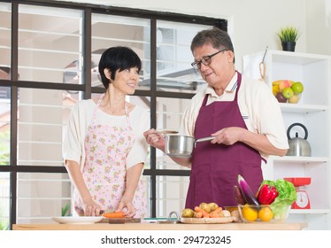 Asian Senior Couple Cooking At The Kitchen

