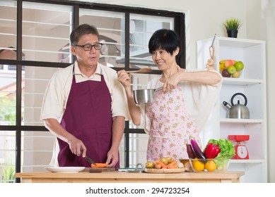 Asian Senior Couple Cooking At The Kitchen

