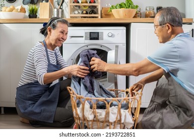 Asian senior couple doing house working and chores in kitchen at home. Active elderly mature grandparents clean and put clothes in washing machine for laundry, enjoy retirement life in house together. - Powered by Shutterstock