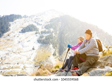 Asian Senior Couple Hiking On The Mountain