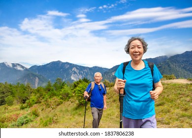 Asian Senior  Couple Hiking On The Beautiful Mountains