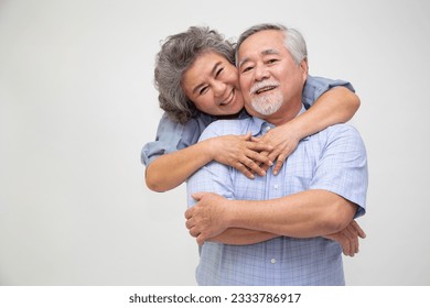 Asian senior couple hugging together isolated over white background, In love anniversary concept - Powered by Shutterstock