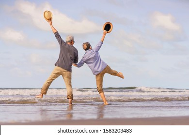 Asian senior couple jumping on the beach.elderly honeymoon together very happiness after retirement.plan life insurance.Activity after retirement on summertime - Powered by Shutterstock