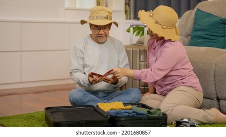 Asian Senior Couple Packing Clothes And Stuff For Travel Trip Together At Home, Senior Retired Couple Enjoying To Arrange Clothes In Living Room, Senior Husband And Wife Organizing Clothes Baggage