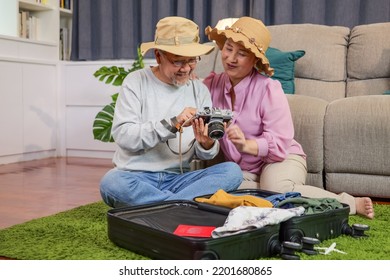 Asian Senior Couple Packing Clothes And Stuff For Travel Trip Together At Home, Senior Retired Couple Enjoying To Arrange Clothes In Living Room, Senior Husband And Wife Organizing Clothes Baggage